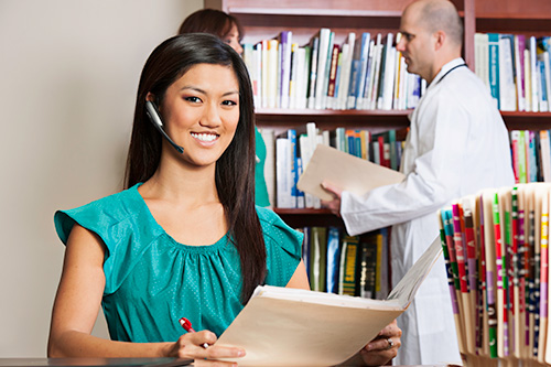 A female medical billing and coding specialist is in the medical office