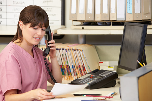 A female Medical Records Technician is working at her desk