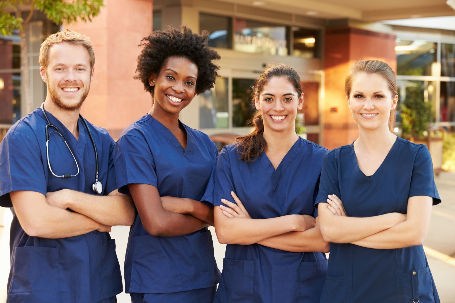 four healthcare professionals are posing for a picture