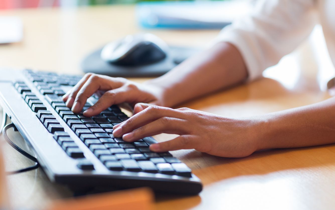 Up close image of someone typing on a keyboard